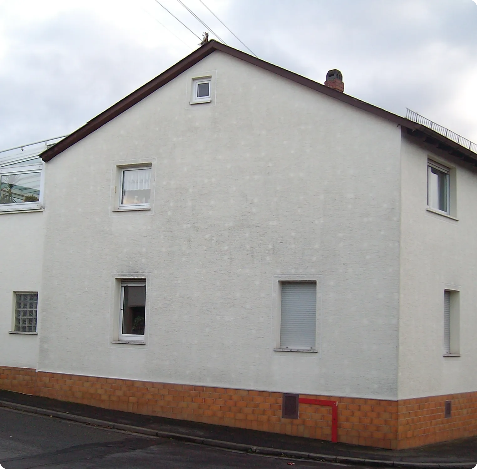 Vorher: Einfamilienhaus mit fleckiger, grauer Putzfassade
