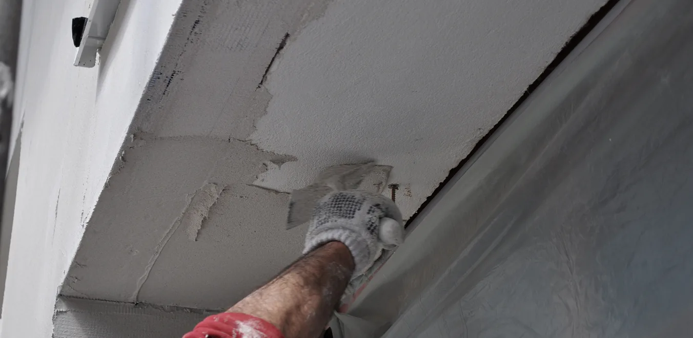 Handwerker verputzt eine Kante mit der Kelle