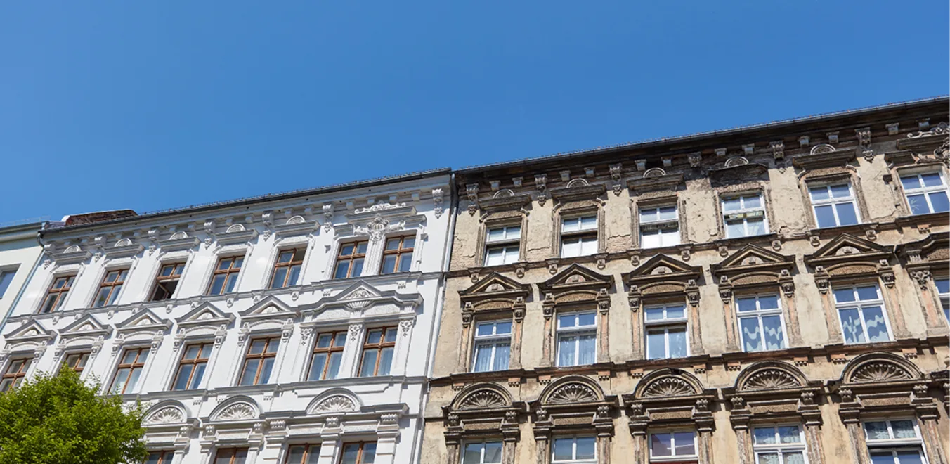 Sanierte Altbaufassaden mit Stuck vor blauem Himmel