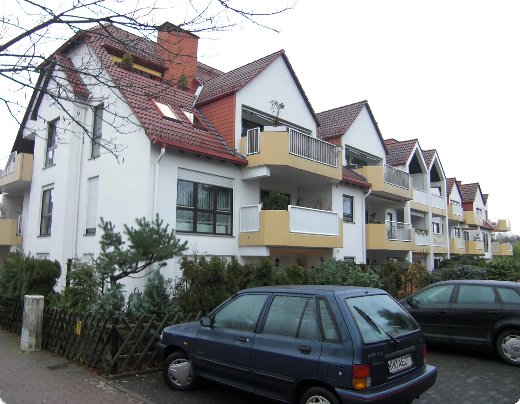 Mehrfamilienhäuser mit hellen Fassaden und gelben Balkonen