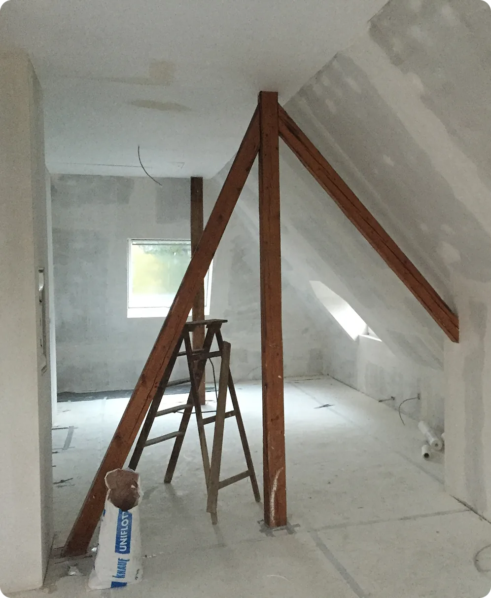Dachgeschoss im Trockenbau mit sichtbarem Holzgebälk und Leiter