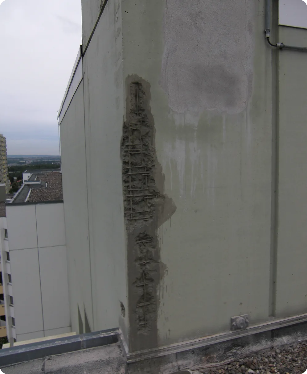 Betonschaden an einer Hausecke mit freiliegender Bewehrung