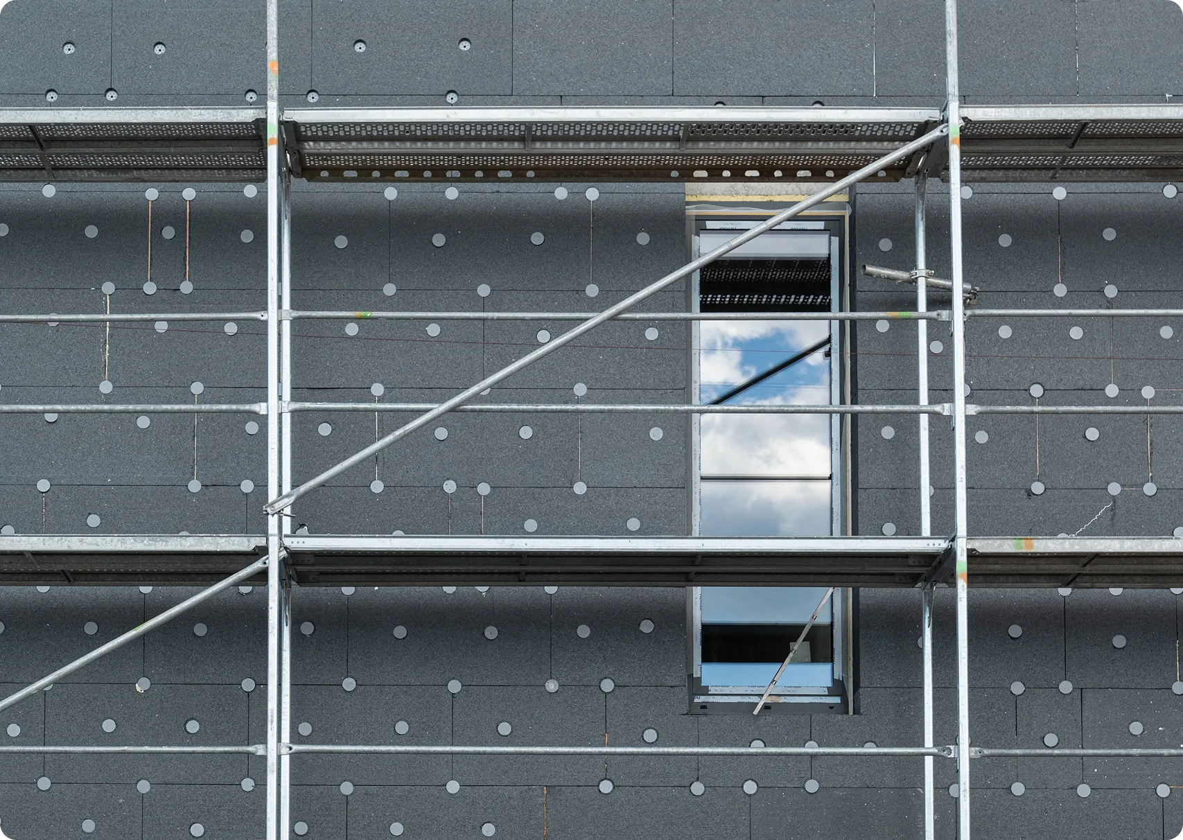Gerüst vor einer gedämmten Fassade mit gedübelten Dämmplatten